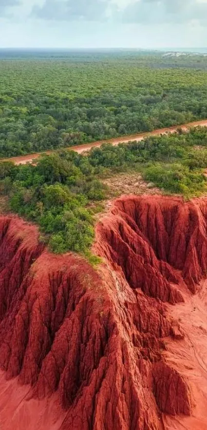 A breathtaking landscape of red cliffs and green forest under a cloudy sky.