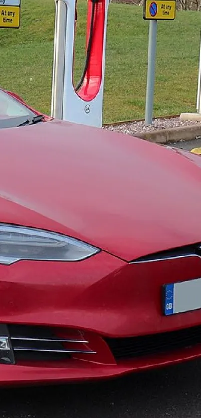 Red electric car parked in charger area with sleek design.