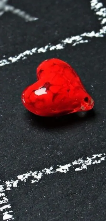 Glossy red glass heart on dark background wallpaper.