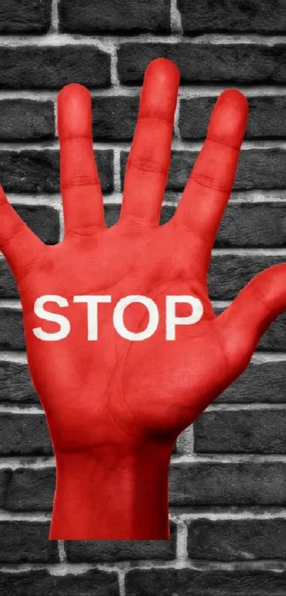 Red hand with 'STOP' on dark brick wall background.