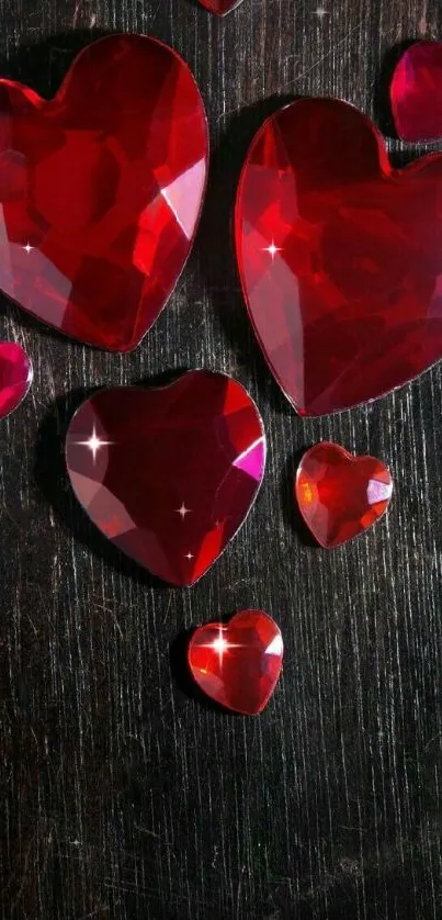 Red gemstone hearts on dark wood background wallpaper.