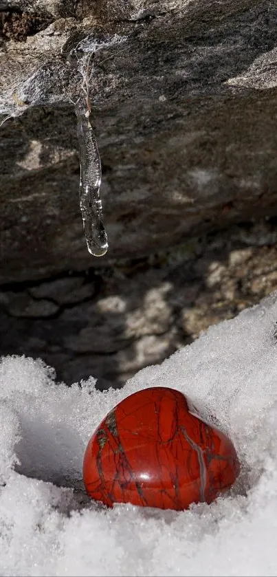 Heart-shaped red stone in winter snow scene.