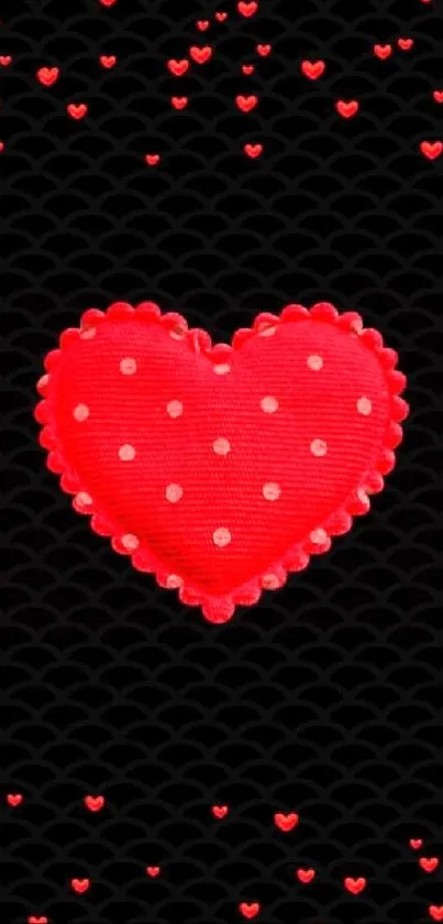 Red heart with polka dots on black wallpaper.