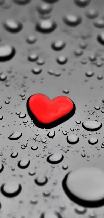 Red heart on a gray surface with water droplets.