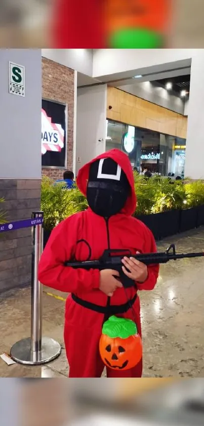 Masked individual in red hood inside shopping center.