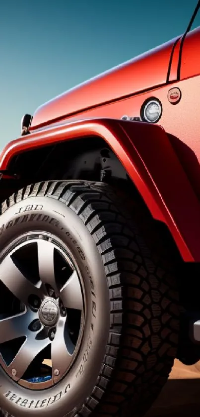 Red Jeep on desert sand with rugged tire.