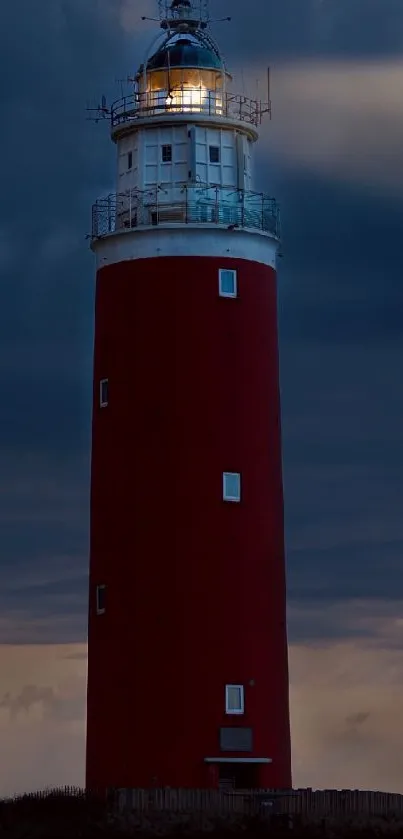 Tall red lighthouse against cloud-filled evening sky.