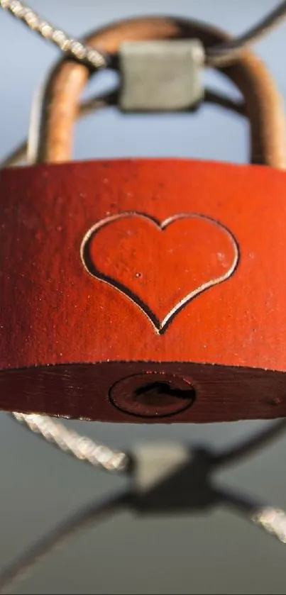 Heart-engraved red padlock on a wire fence.