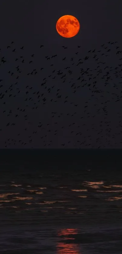 Red moon over ocean with birds flying at night.