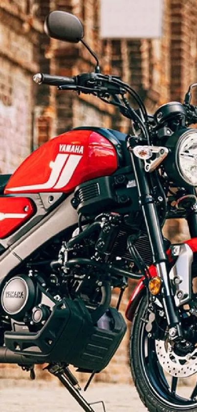 Red motorcycle parked in an urban alleyway with vintage brick walls.