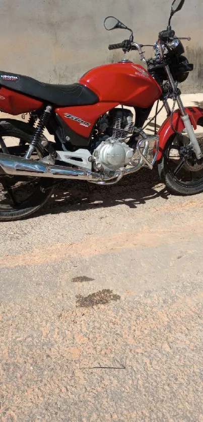 Red motorcycle parked on a sunny street.