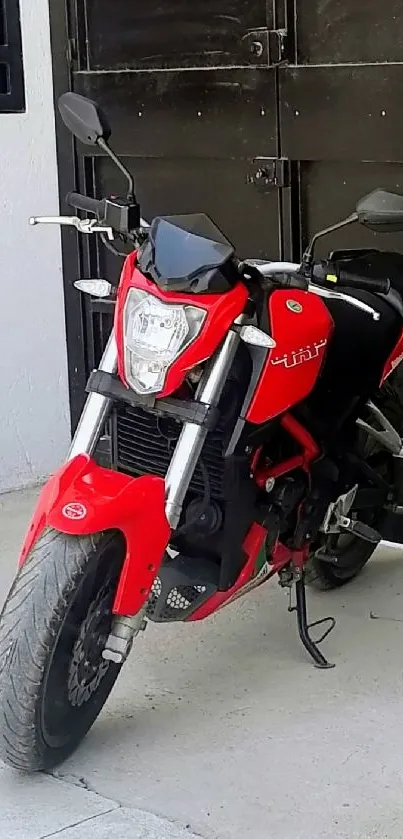 Red motorcycle parked by a black door.