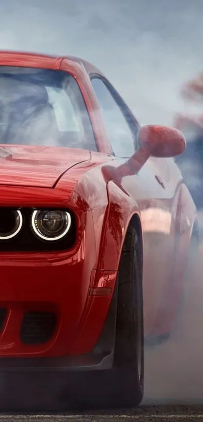 Red muscle car drifts in smoke on road, showcasing speed and power.