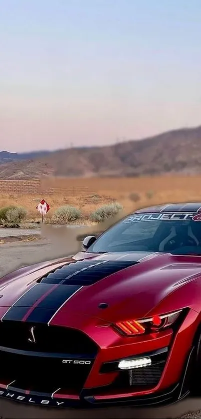 Red Mustang GT500 in scenic desert landscape.