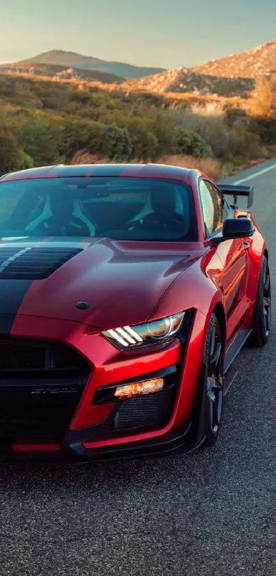 Red Mustang driving on a scenic mountain road.