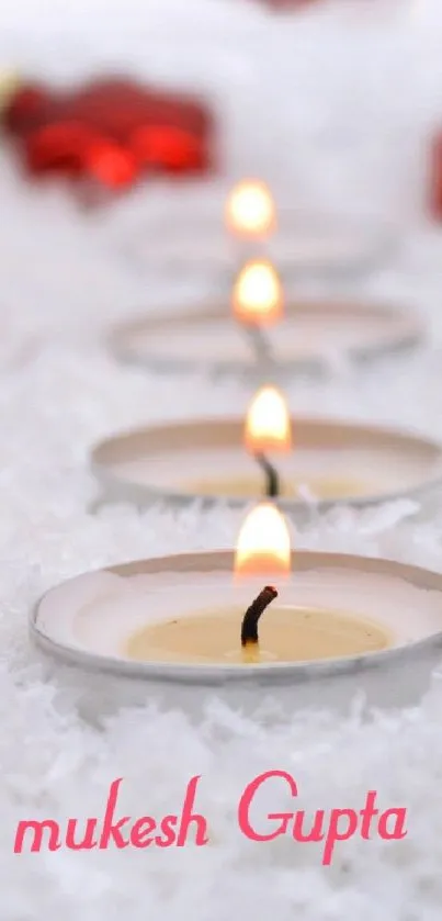 Mobile wallpaper with red ornaments and candles on snow.