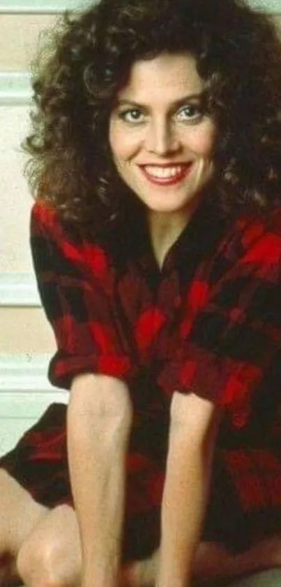 Woman with curly hair in red plaid on vintage wallpaper.