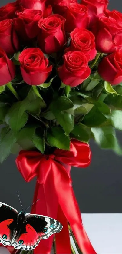 A bouquet of red roses with a red ribbon and a butterfly.