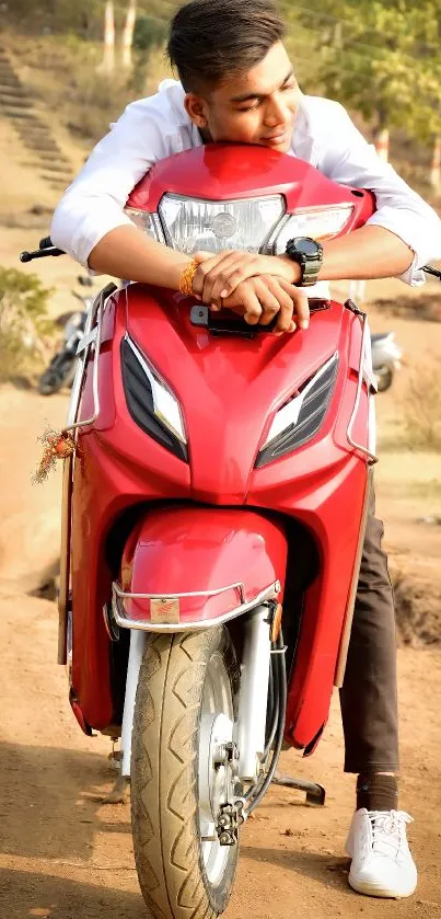 Red scooter with a young man in a scenic countryside setting.