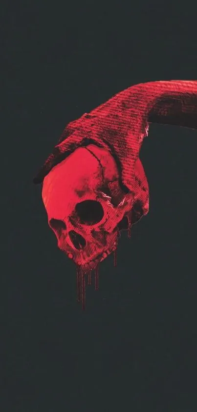 Red skull held by a hand on a black background wallpaper.