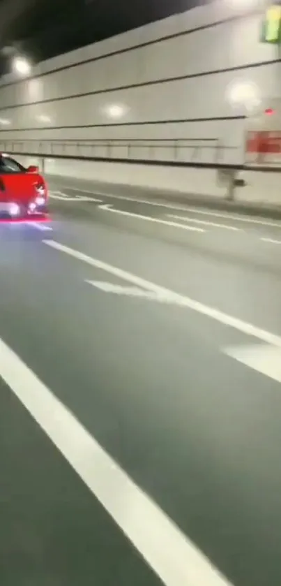 Red sports car speeding through a tunnel at night.