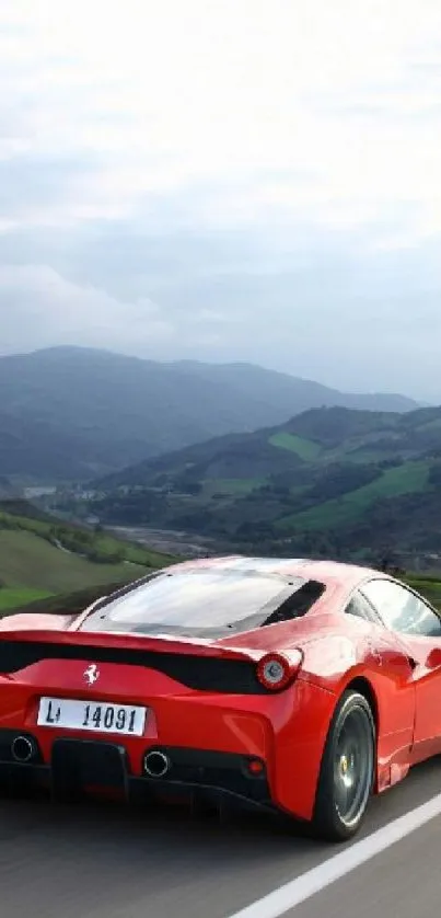 Red sports car on scenic open road with mountains.