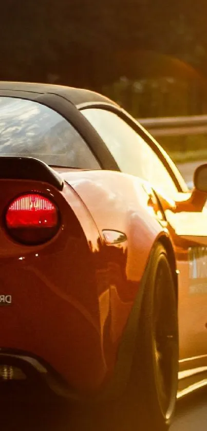 Red sports car driving into the sunset on a highway.