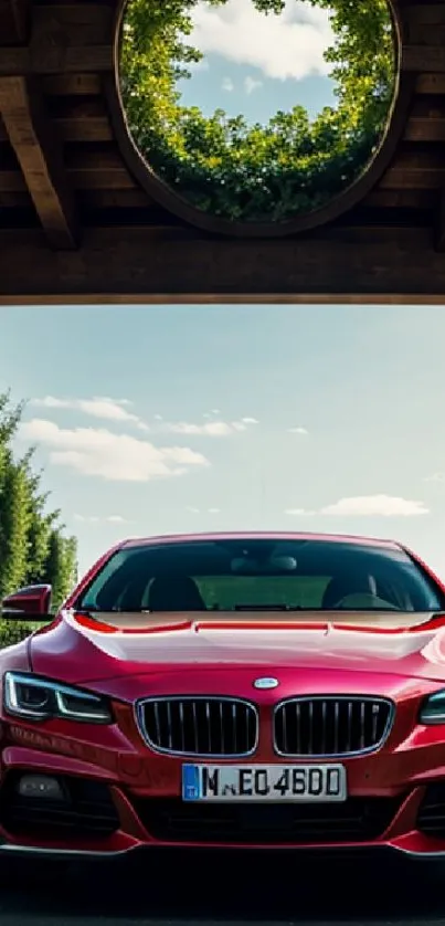 Red sports car under an archway with a clear sky backdrop.