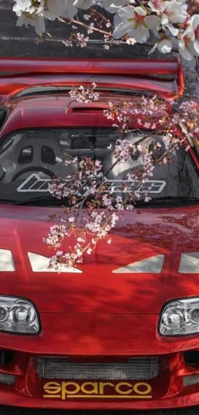 Red sports car framed with cherry blossoms.