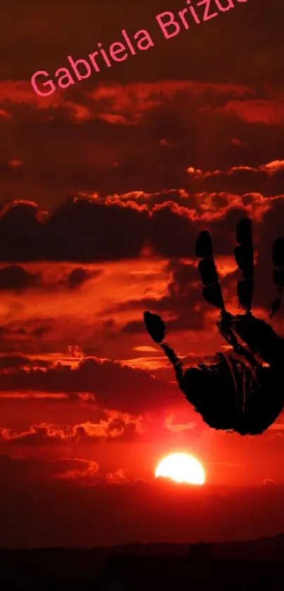 Red sunset with black handprint silhouette on wallpaper.