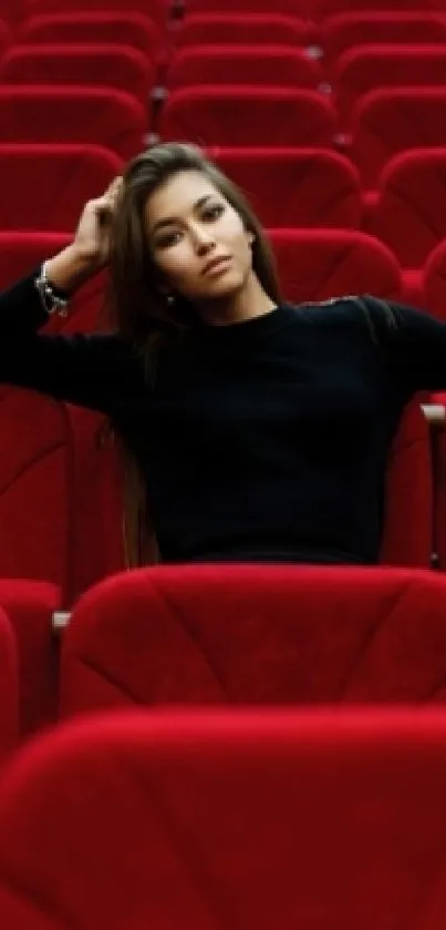 Person seated among red theater chairs, creating a striking contrast for a phone wallpaper.