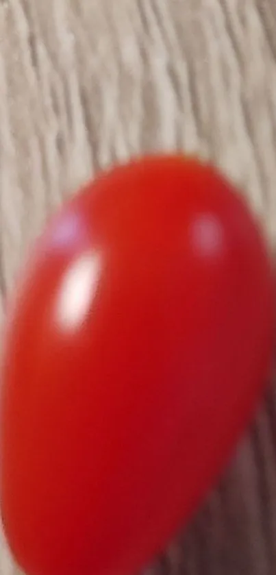 Mobile wallpaper featuring a red tomato on wood.