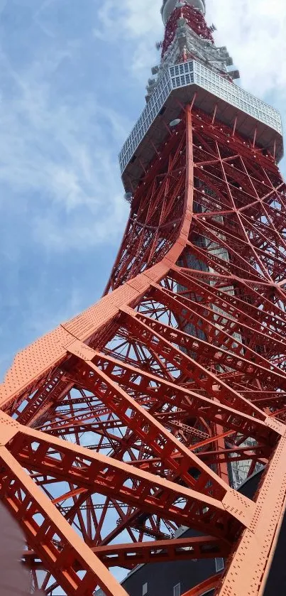 Red steel tower structure against a clear blue sky, showcasing urban architecture.