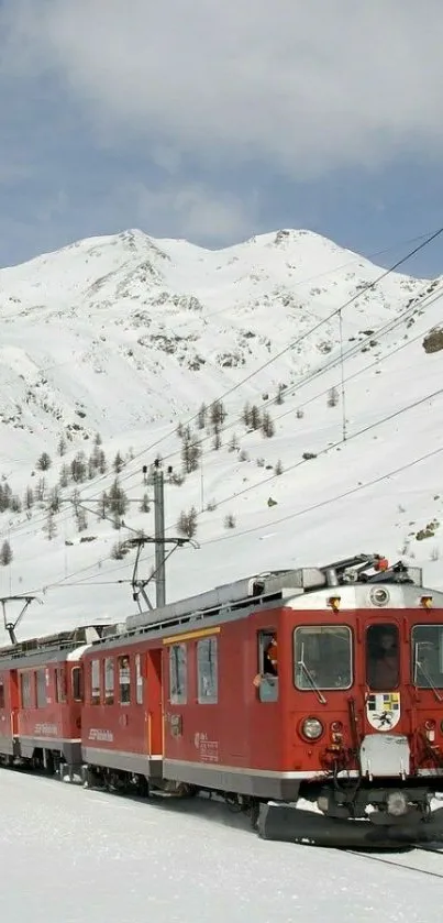 Red train traveling through snowy alpine mountains.