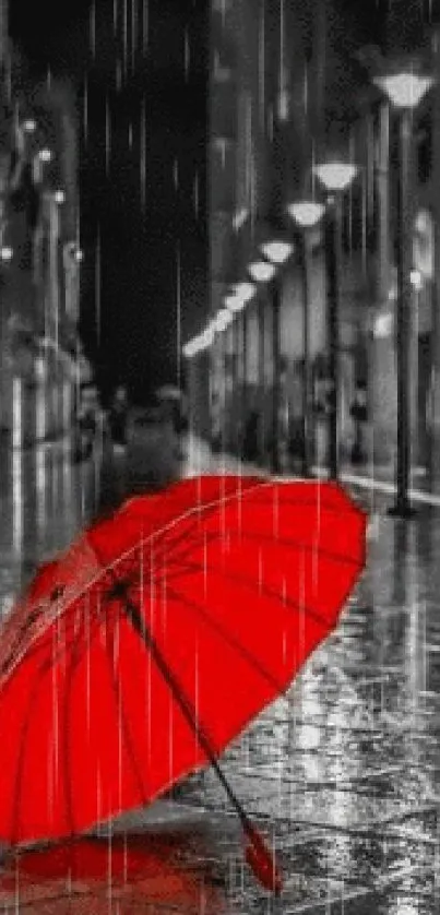 Red umbrella on a rainy night street with vivid contrast.