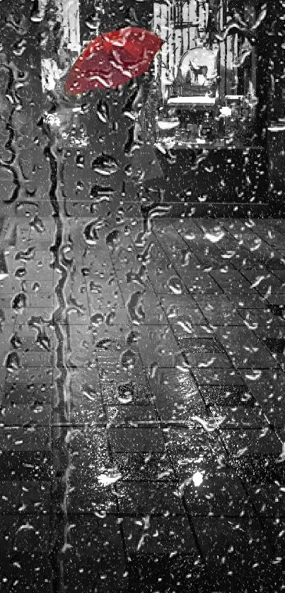 A person with a red umbrella walks in the rain at night on a wet city street.