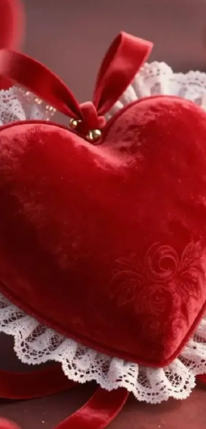 Red velvet heart with lace trim on a mobile wallpaper background.