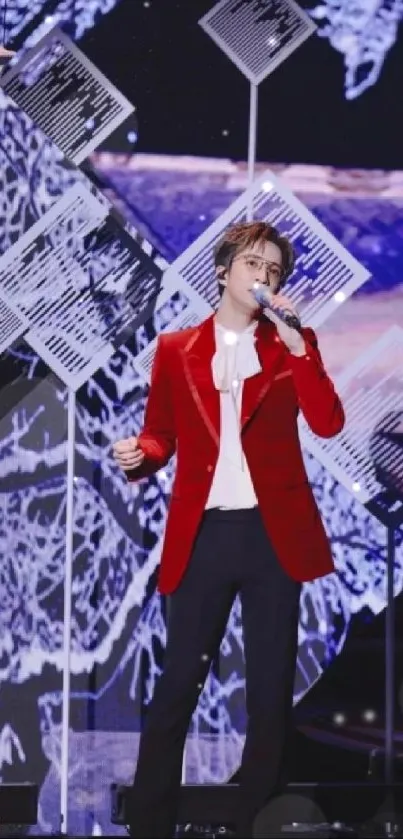 Performer in a red velvet jacket on stage with black and white background elements.