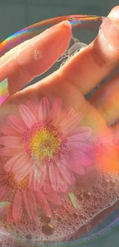 Hand holding a soap bubble with a pink flower inside.