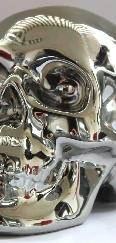 Reflective metallic skull with chrome finish on white background.