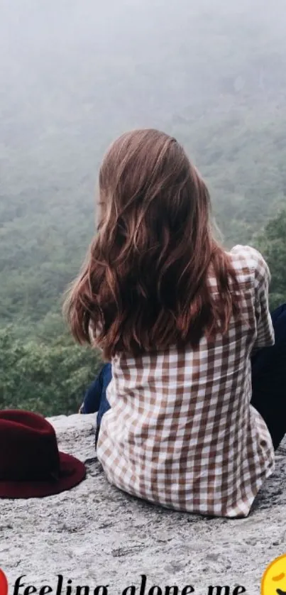 Girl sitting alone on a misty cliff with scenic background.