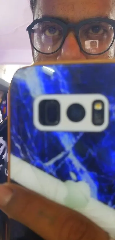 Vibrant blue marble phone case reflection in a mirror.