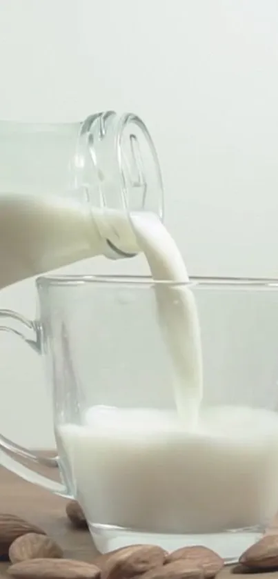 Almond milk being poured into a clear glass on a wooden table.