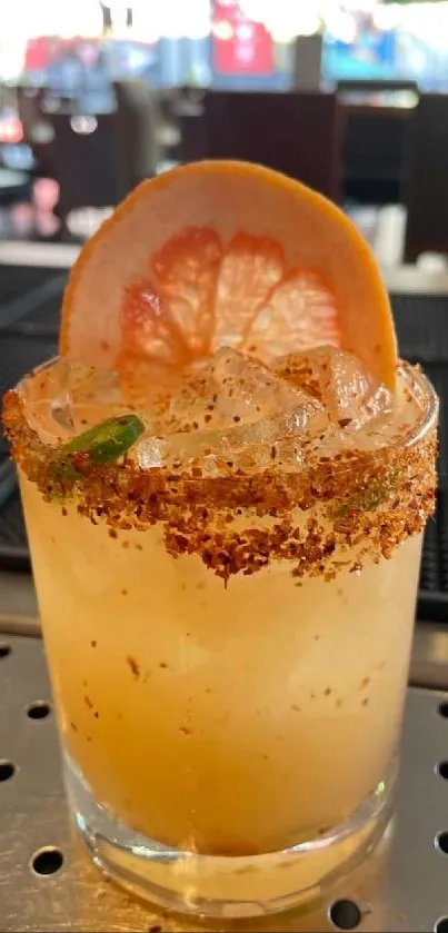 Refreshing citrus cocktail with grapefruit slice and spicy rim in bar setting.