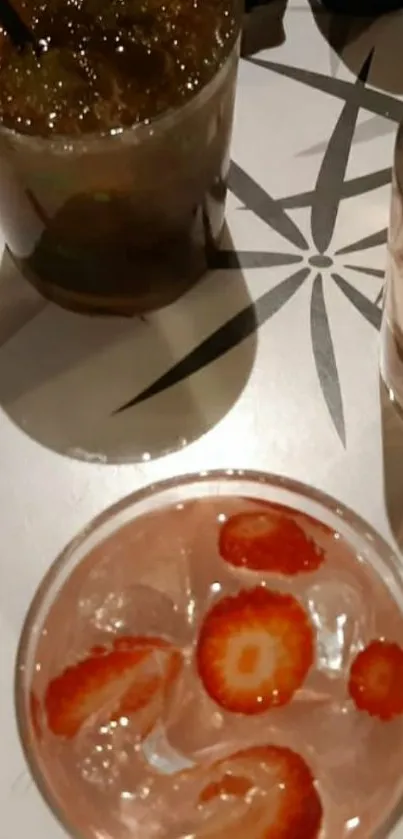 Close-up of cocktails with strawberries and ice on a stylish table.