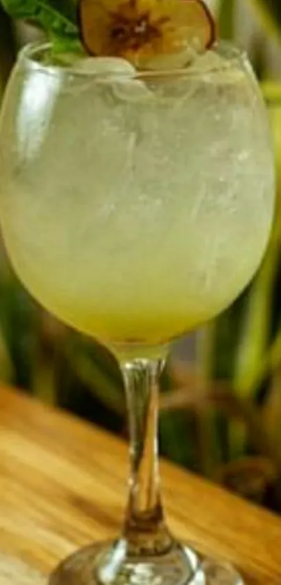 A refreshing cocktail in a glass with a fruit garnish on a wooden surface.