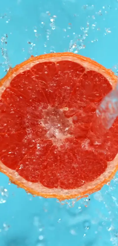 Grapefruit slice splashing in water on a sky blue background.