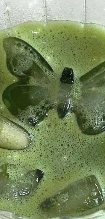 Vibrant green drink with butterfly ice cubes in a glass.