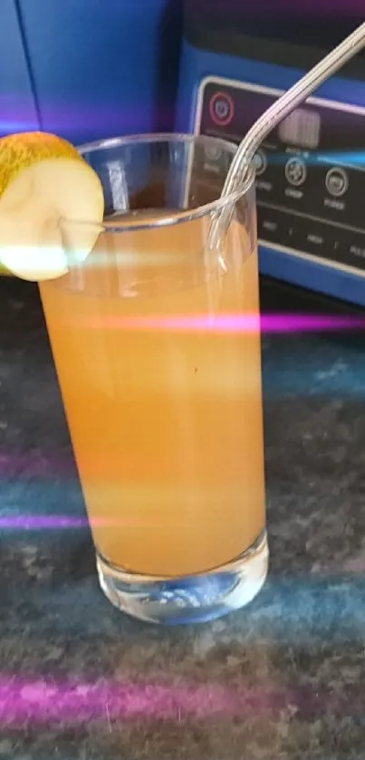 Glass of orange juice with metal straw on countertop.