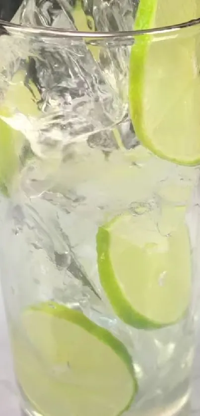 Glass of lime drink with ice cubes and slices, refreshing wallpaper.